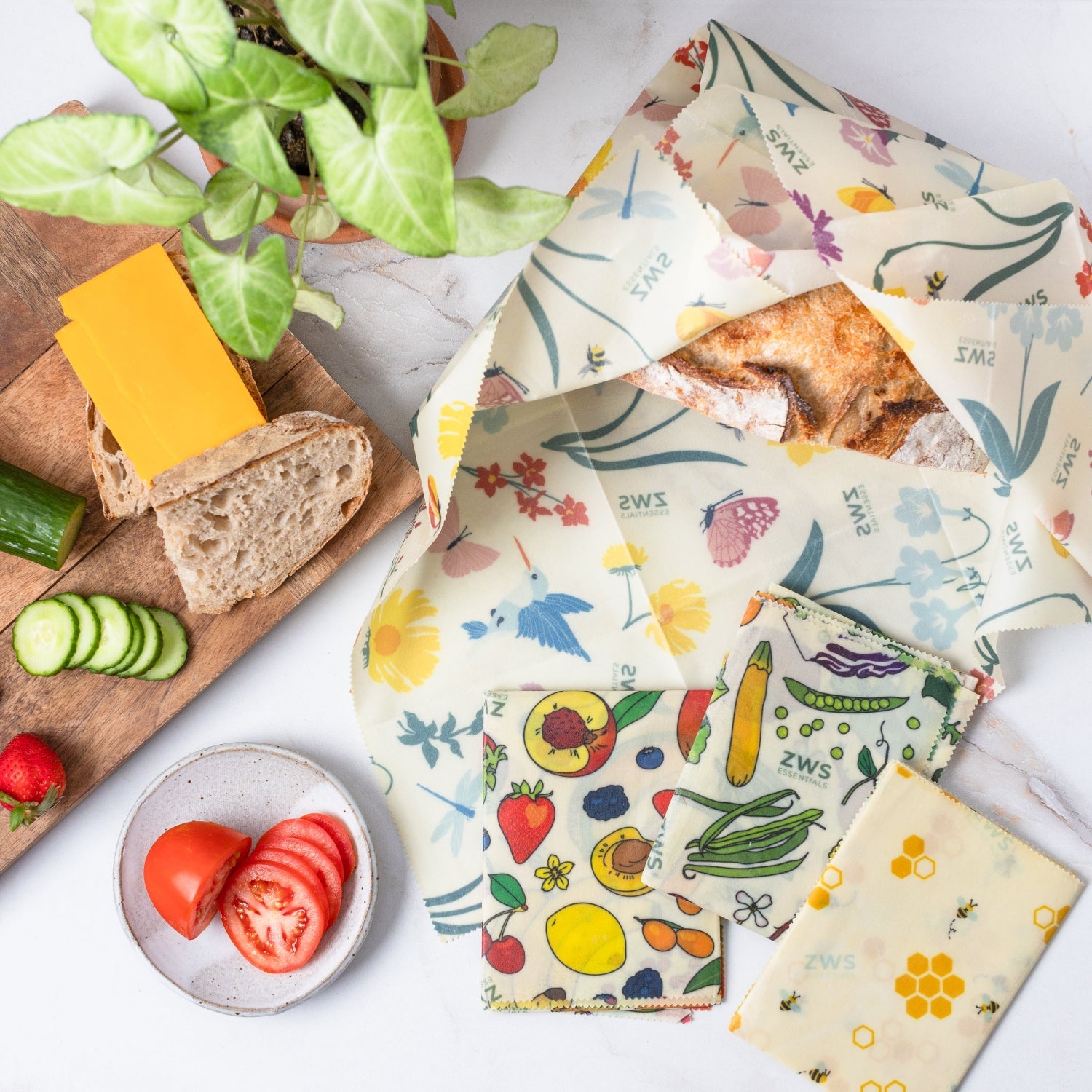 Set of reusable food wraps with colorful patterns on a white surface with food items.