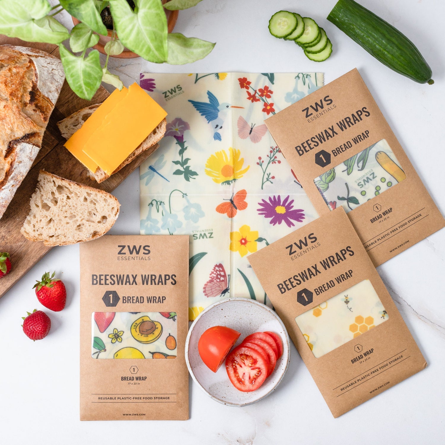 ZWS beeswax wraps with bread, cheese, and vegetables on a white surface