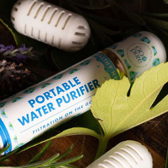 Portable water purifier with leaves and lavender on a wooden surface