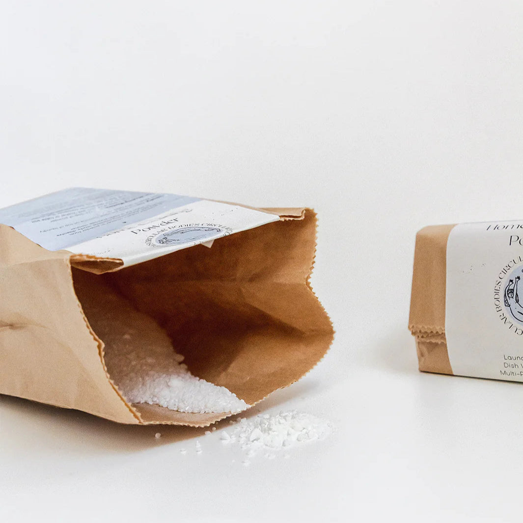 Open brown paper bag with white contents on a light gray background