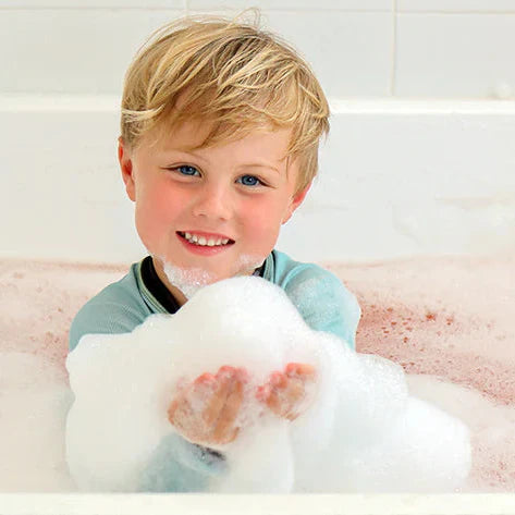 Child playing with bubbles in a bathtub